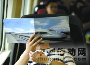 運(yùn)行的高鐵列車上，一名記者在看材料。